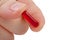 Red pill in fingers close-up.