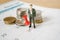 Red pin marked the last day of month on white calendar with blurred miniature businessman and coins