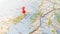 A red pin stuck in the island of Jura on a map of Scotland