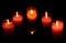 Red and pink candles in glass cups transparent densest darkness.