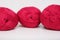 Red pink colorful skeins of yarn close up, fuchsia color woolen yarn for crochet and knitting, hobby and handmade concept