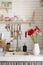 Red and pink gerbera daisies in a white vase on a wooden kitchen counter next to the sink. Rustic kitchen interior
