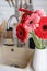 Red and pink gerbera daisies in a white vase on a wooden kitchen counter. Rustic kitchen interior design