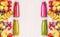 Red,pink,green and yellow smoothies and juices beverages in bottles with various fresh organic fruits and berries ingredients on w