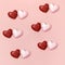 Red and pink polygonal paper hearts together on crem colored surface. Holiday background with copy space for Valentines