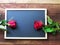 Red and pink roses placed on the blackboard on the wooden background. Valentine`s Day background