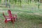 Red plastic Adirondack chairs on the back lawn, under a weeping willow, wood fence separating yard from pasture