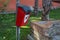 Red plastic bin for dog poo in the park. Image of dog on the container.