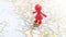 A red plastic figure standing on Rome on a map of Italy