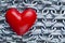 Red plastic heart on steel chains background