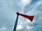 A red plastic horn tie with a white plastic pipe with blue sky background