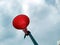 A red plastic horn tie with a white plastic pipe with blue sky background