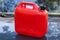 Red plastic jerry can stands on car hood