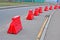 Red plastic pylon barrier line on the street, security diversity,