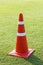 Red plastic traffic cone on green grass