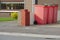 Red plastic wheelie bins in drive way by a house. Recycle industry. Waste containers ready for collection in a residential area