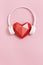 Red polygonal paper heart shape in white headphones. Music concept. Dj Headset. Minimal style