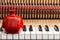 Red pomegranate on the close up image of grand piano keys and interior showing strings, hammer and structure background