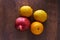 Red pomegranate, yellow lemon and an orange on a wood background top view