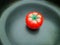 Red pomodoro timer in tomato shape on a black texture background