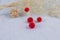 Red pompon earrings in the shape of two fluffy balls.Earrings are next to rattan products, flower specimens and other ornaments