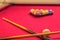 Red pool table with cue sticks billiard balls