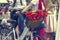 Red poppies in a bicycle basket. Woman in red skirt holds the handlebar