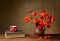 Red poppies in a ceramic vase, books and metal pots