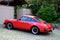 Red Porsche car parked near the house in the historic district old european city, German sports car manufacturer, Hall in Tirol,