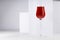 Red port wine in rich high glass in sunlight with shadow in modern minimal abstract white interior with geometric spaces