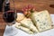 Red porto and cheese pairing, blue matured stilton English cheese served as dessert with walnuts and glass ruby porto wine