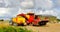 Red potato lifter loads grubbed potatoes in a yellow cereal tipping