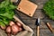 Red potatoes on burlap with greenery and a garden spade and rake on a wooden brown background