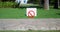 Red prohibition sign on white background in a green park on lawn on sunny day