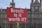 Red protest sign with text Brexit is it worth it in the front of the houses of