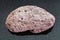 red pumice pebble on dark background