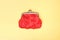 Red purse on a yellow background. Red wallet for coins