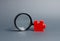Red puzzle and magnifying glass. The concept of finding the missing detail or element in the general plan or strategy. Business