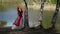 red queen in gorgeous dress is walking in forest near river, fantastic character from fairytale