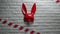 Red rabbit mask on a white brick texture wall and red and white signal tape