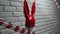 Red rabbit mask on a white brick texture wall and red and white signal tape