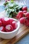 Red radishes in a white ceramic bowl portrait crop