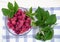 Red rasberries in a bowl with leaves