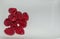 Red raspberries in a small pile on a white plate.