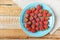 Red raspberry in blue dish and in front of white fabric on old vi