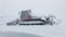 Red ratrak snowcat in winter mountains. A red snow tucker covered with snow.