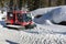 Red ratrak snowcat in winter mountains A red snow tucker covered with snow in Krkonose mountain. Red over-snow vehicle,