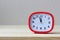 Red rectangular plastic alarm clock on the table