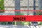 Red reflective danger barrier tape across a chain link fence
