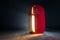 Red refrigerator retro fridge with opened doors emit steam and bright warm white light in dark empty room